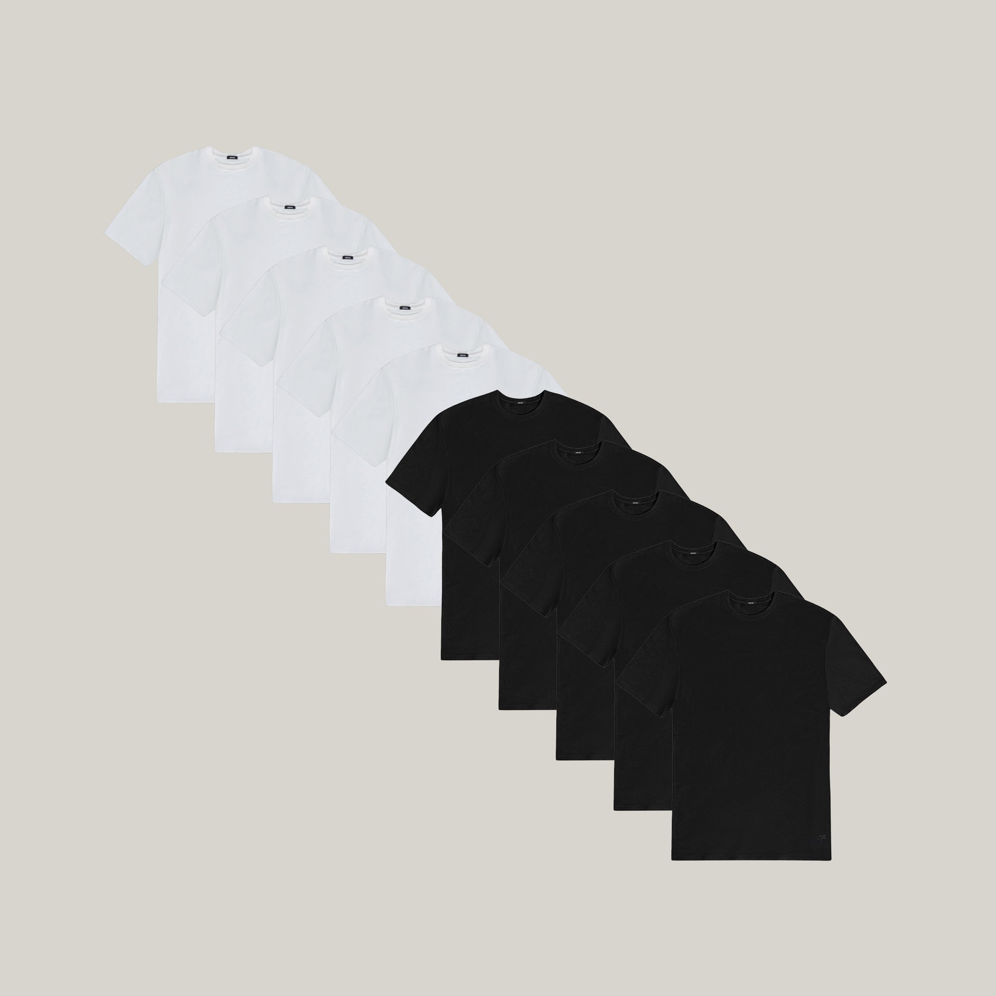 Ten t-shirts in Black and White on a beige background model Tyler in Essential
