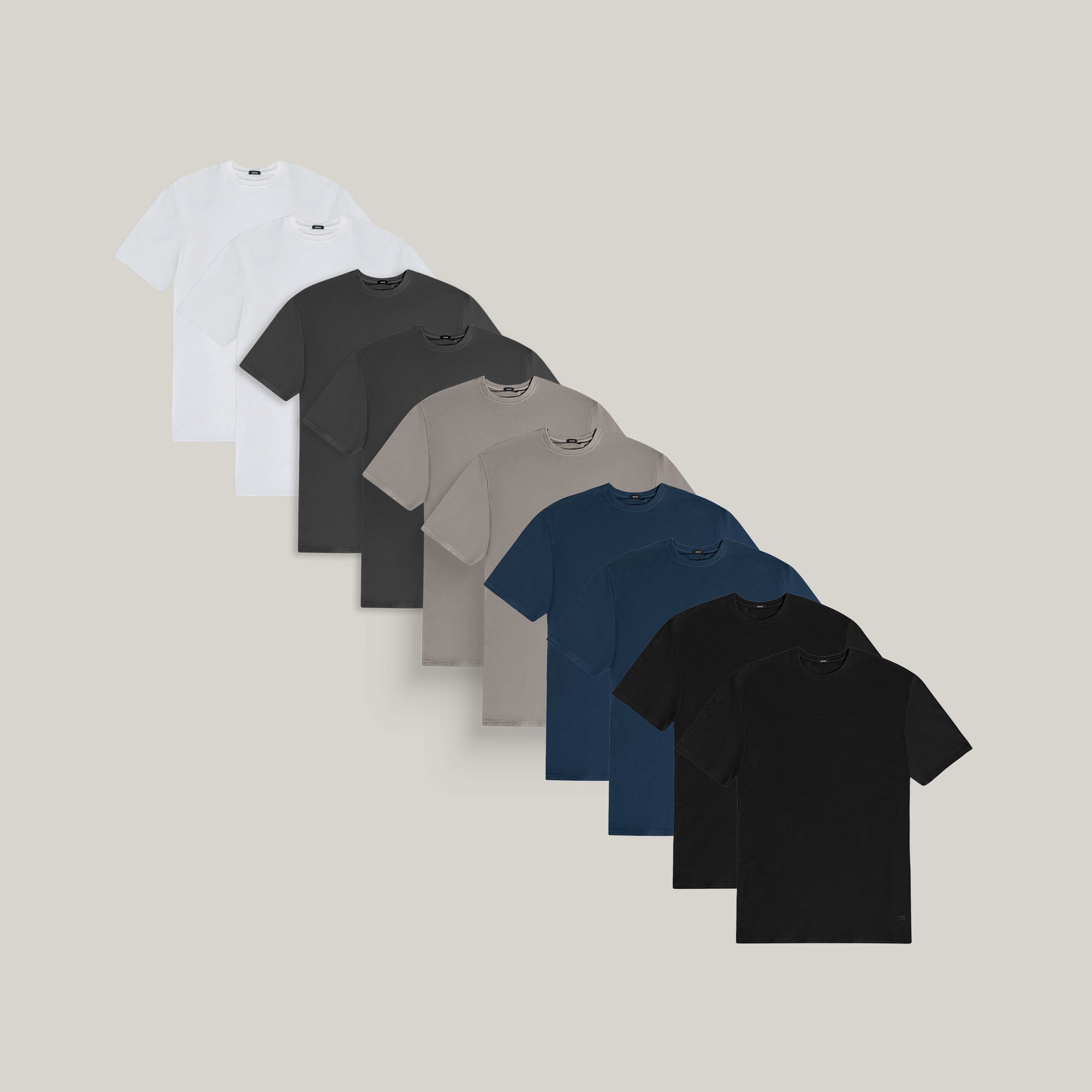 Ten t-shirts in Black, Deep Sea, Moss, Umber, Frost Gray, and White on a beige background model Tyler in Best-Seller