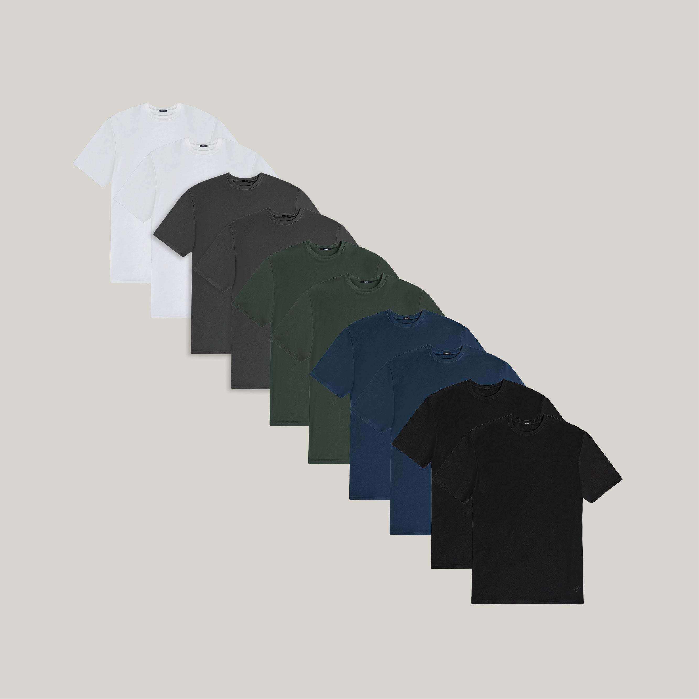 Ten t-shirts in Black, Deep Sea, Moss, Umber, Frost Gray, and White on a beige background model Tyler in Best-Seller