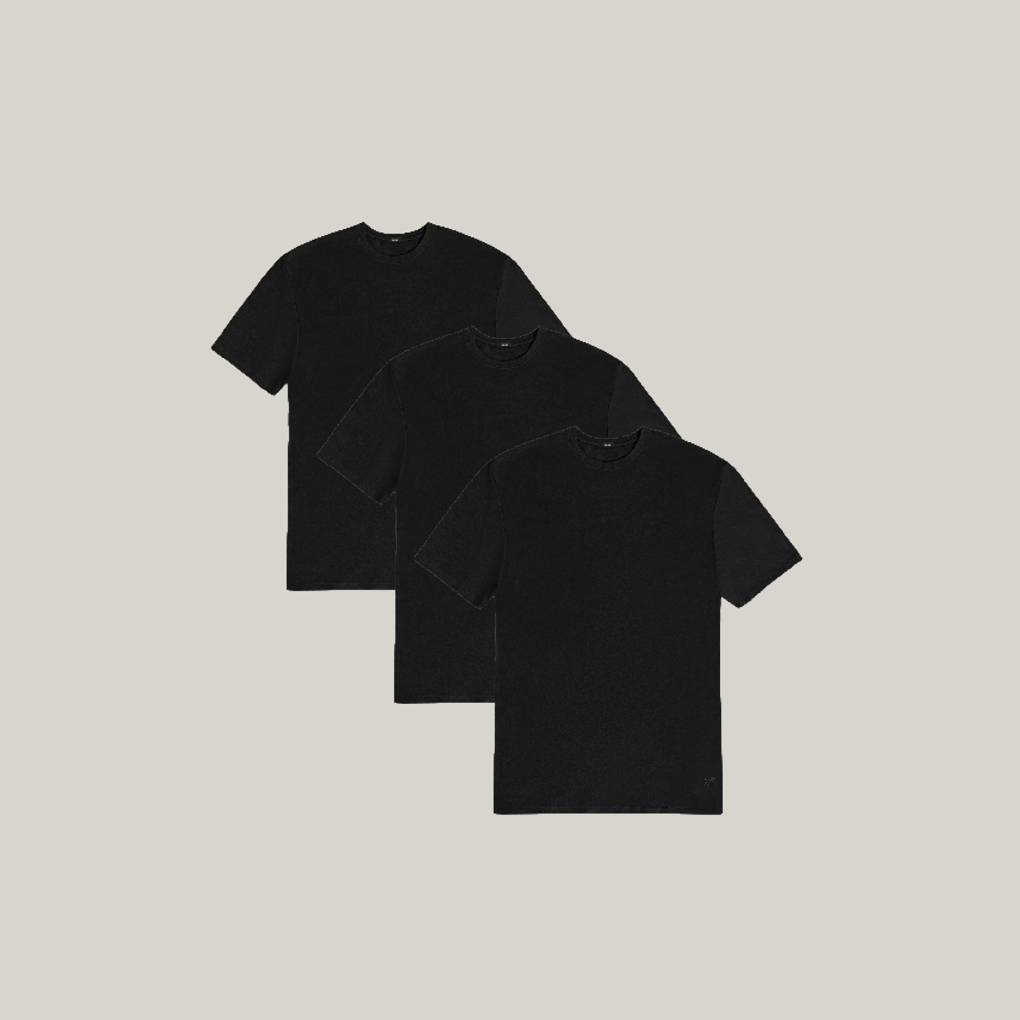 Three black t-shirts stacked on a beige background model Tyler in All-Black