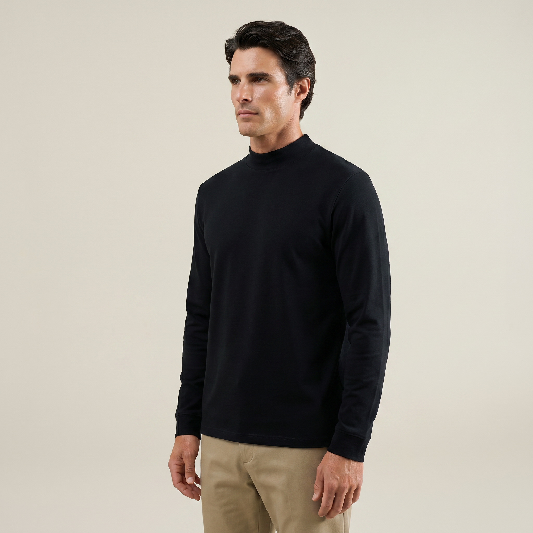 Man wearing a black long-sleeve shirt and beige pants against a beige background model kive in black