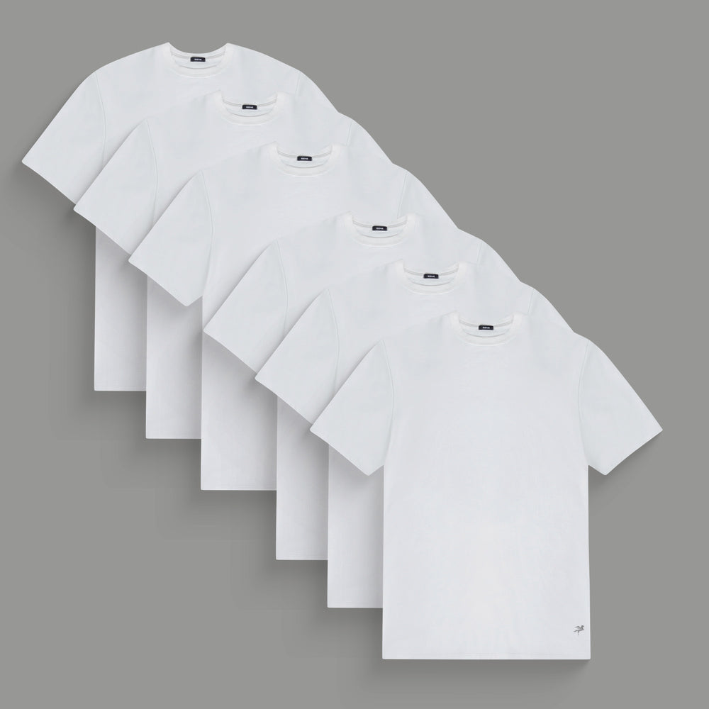 Six plain white t-shirts arranged in a staggered layout on a gray background.