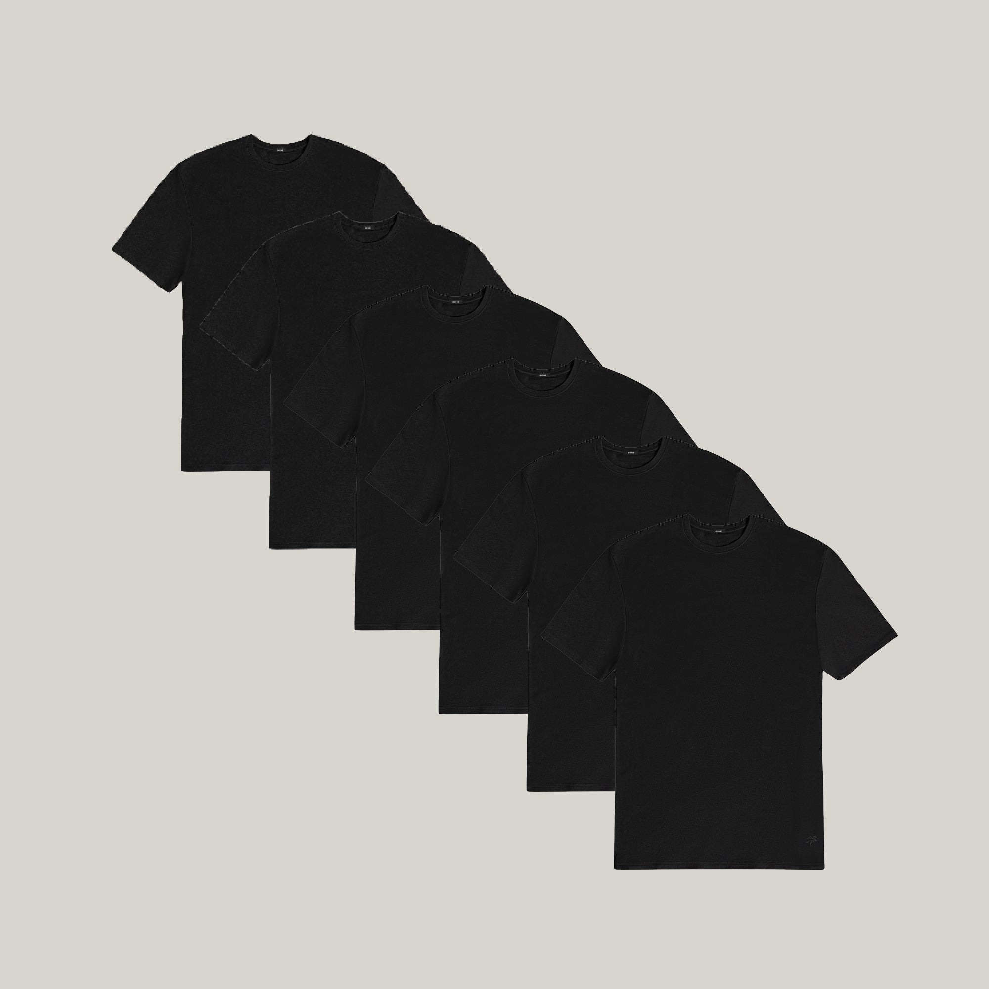 Six black t-shirts stacked on a beige background model Tyler in All-Black