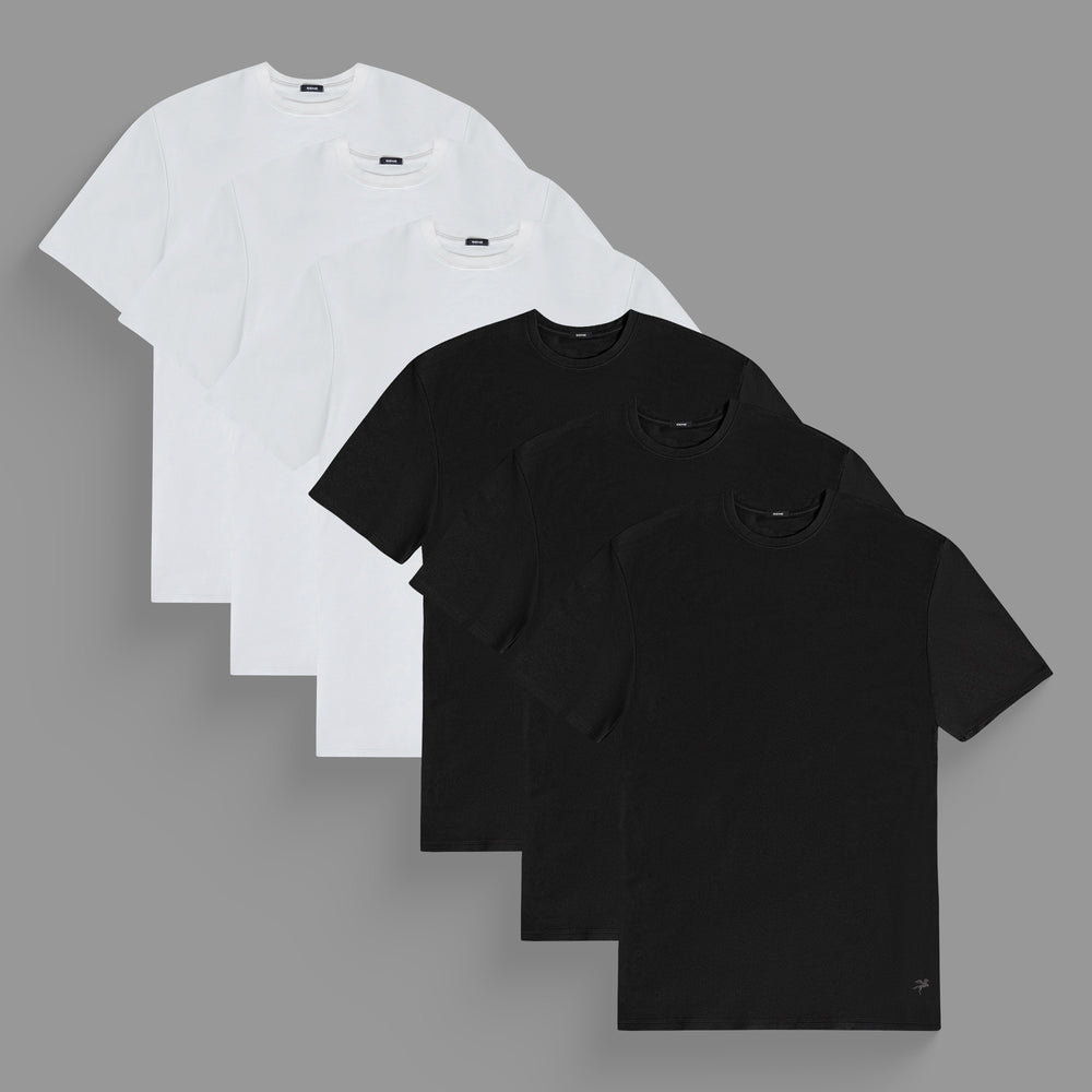 Four white and four black T-shirts arranged in alternating layers on a gray background.