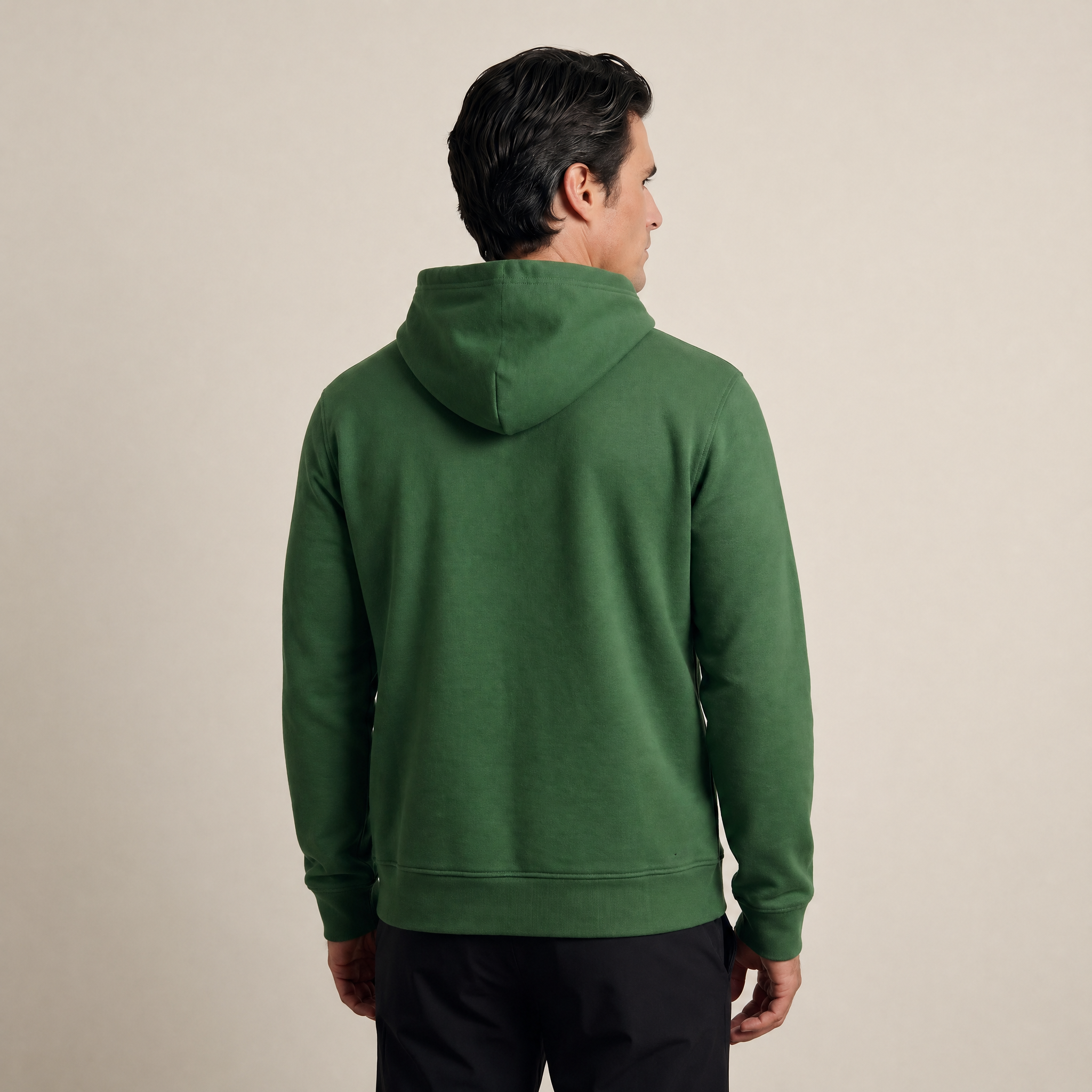 Man wearing a green hoodie from behind on a beige background model Kive in Eden