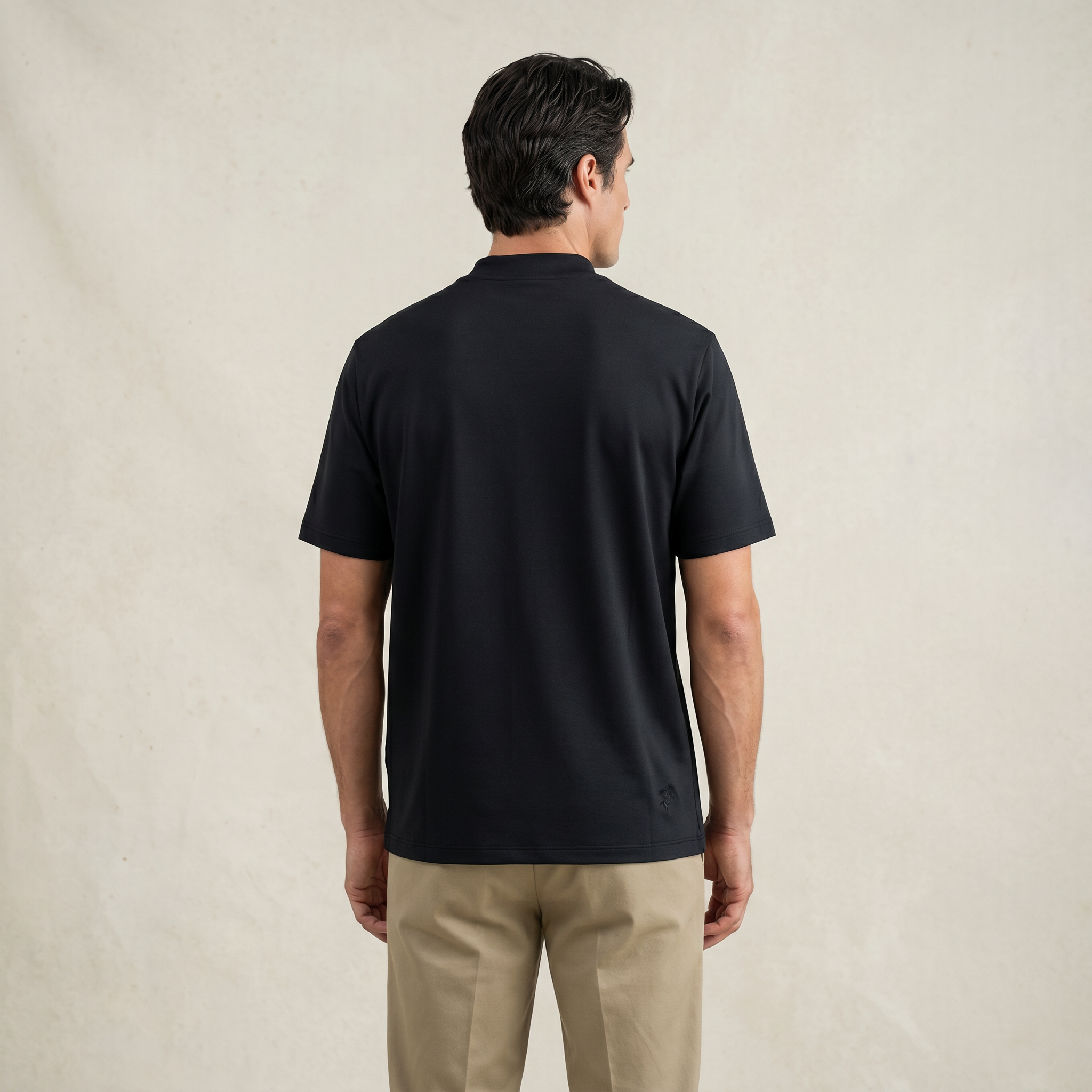 Man wearing a black short-sleeve shirt against a beige background model Kive in black