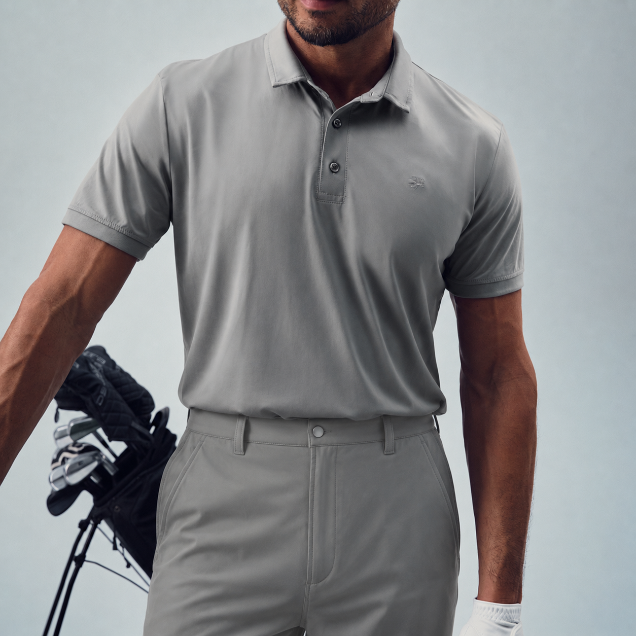 Man custom-fit gray golf attire holding a golf club model chad in glacier