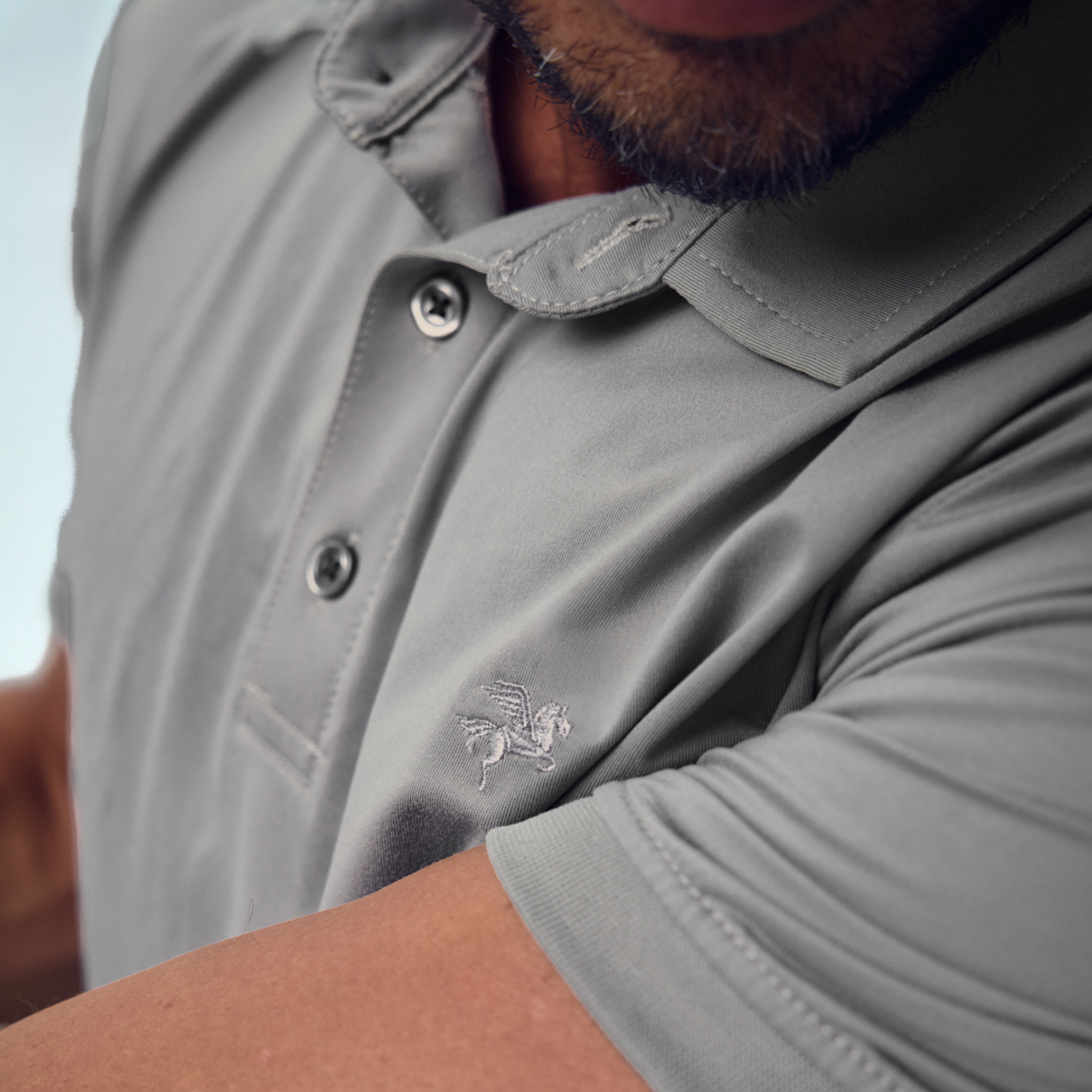 Man custom-fit gray golf attire holding a golf club model chad in glacier