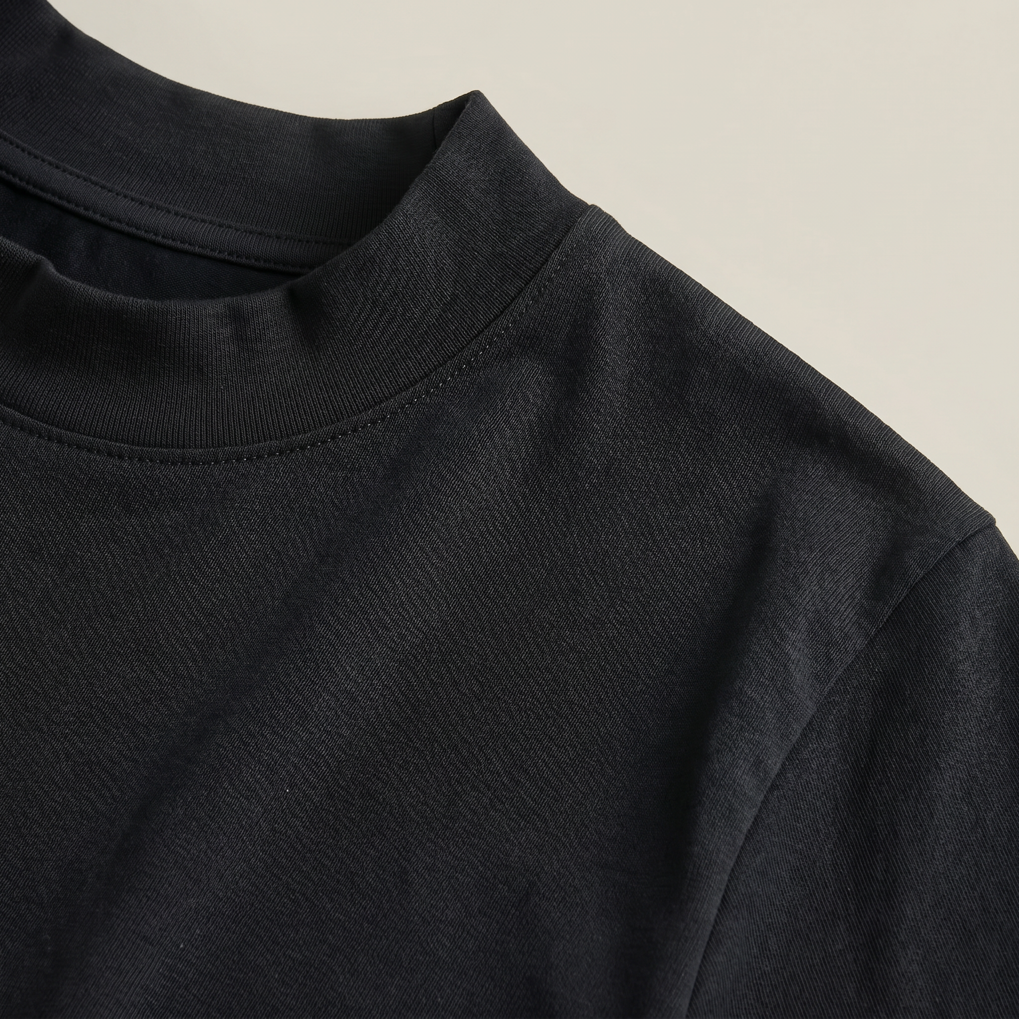 Close up of black mockneck short-sleeve shirt in black with beige background model Kive in black