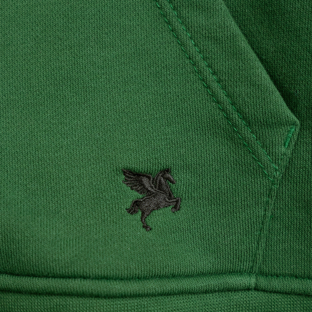 Close-up of a green garment with a small logo on the sleeve model Kive in eden