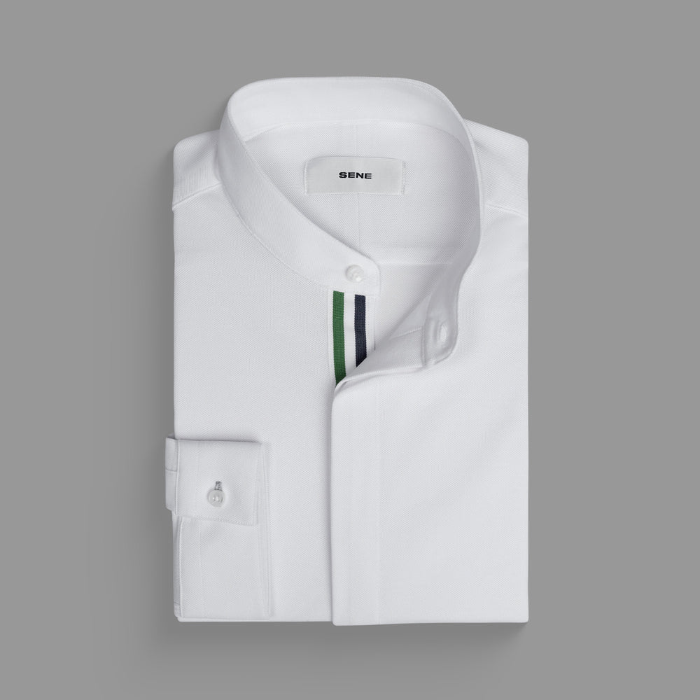 Folded white dress shirt with a green and blue striped accent inside the collar.