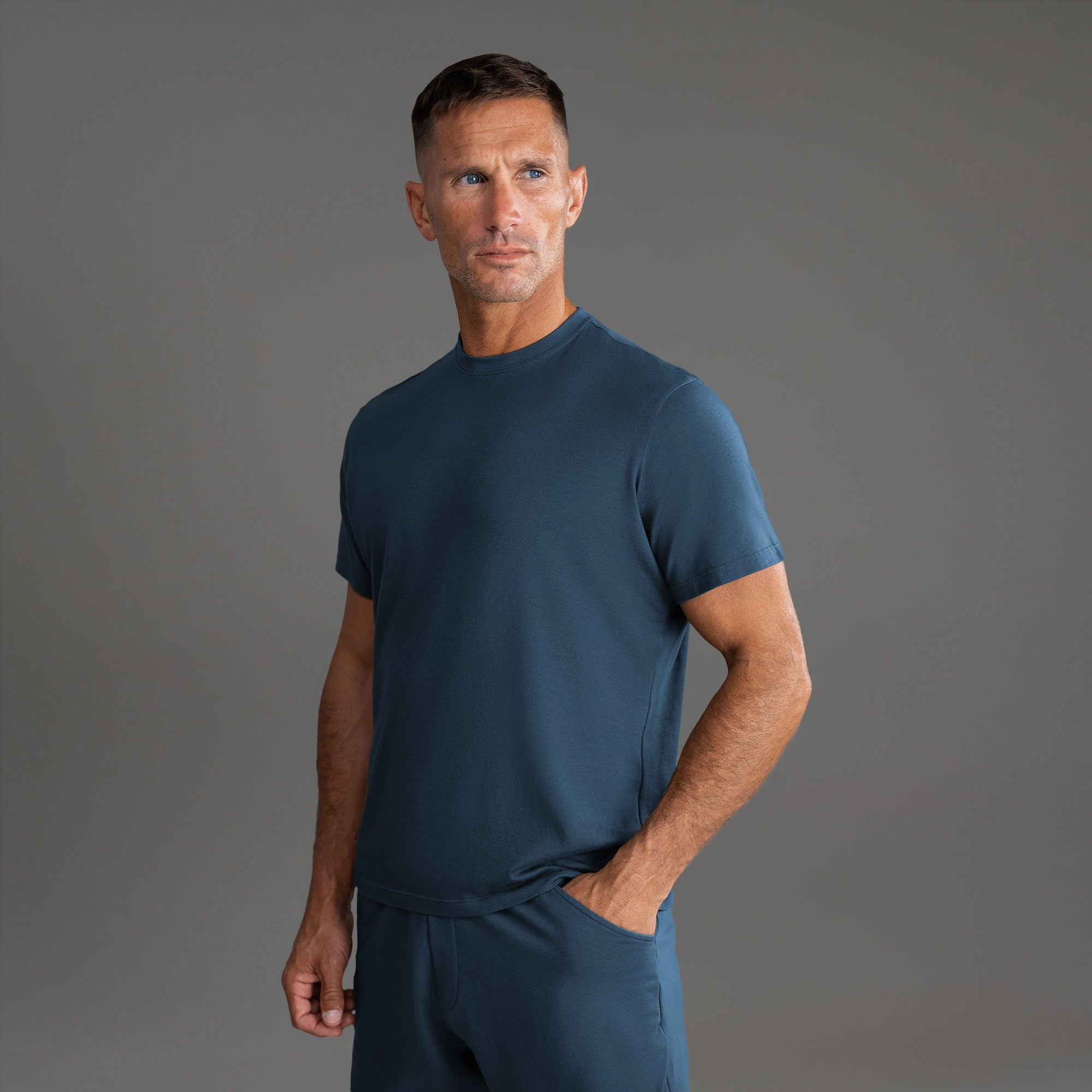 Three t-shirts in black, blue, and white on a beige background model Tyler in Shade