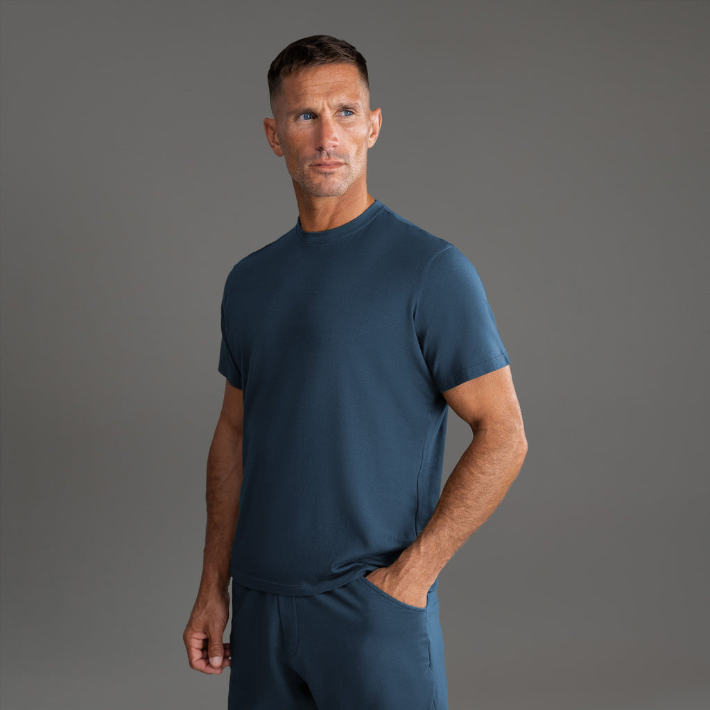 Six t-shirts in Black, Deep Sea, Moss, Umber, Frost Gray, and White on a beige background model Tyler in Best-Seller