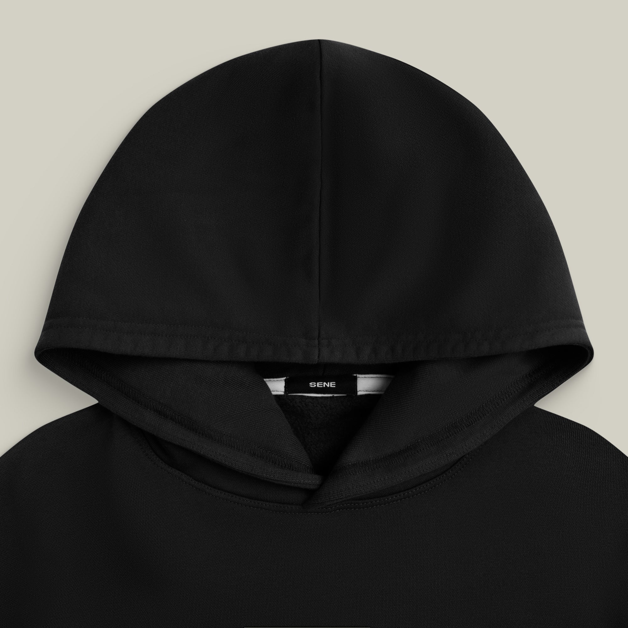 Black hoodie with a brand label on a light gray background model Kive in Black