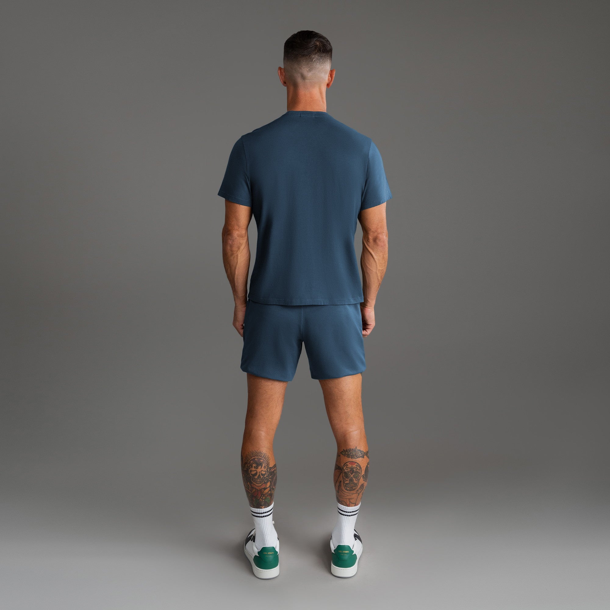 Ten t-shirts in Black, Deep Sea, Moss, Umber, Frost Gray, and White on a beige background model Tyler in Best-Seller
