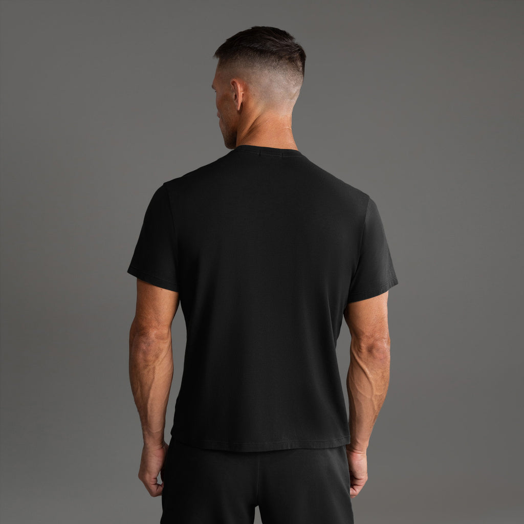 Three t-shirts in black, blue, and white on a beige background model Tyler in Shade