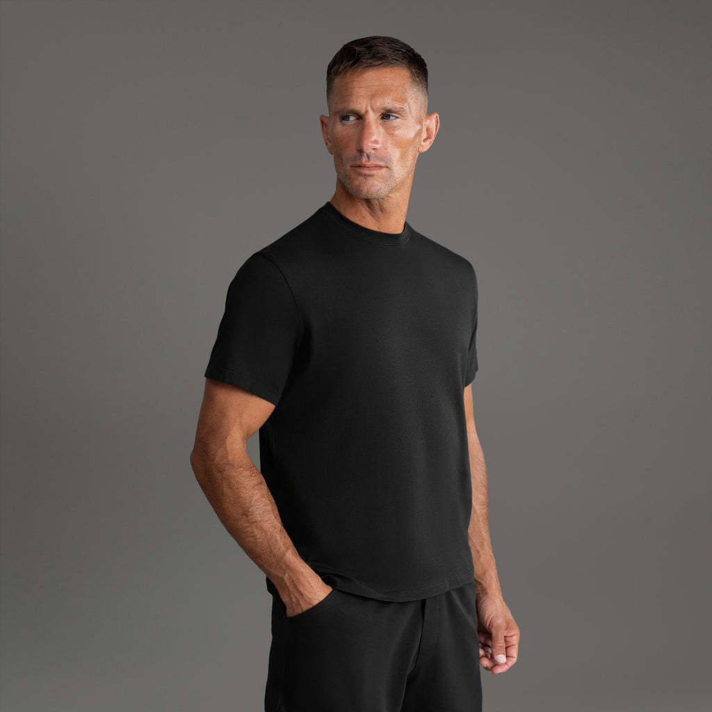 Six t-shirts in Black and White on a beige background model Tyler in Essential
