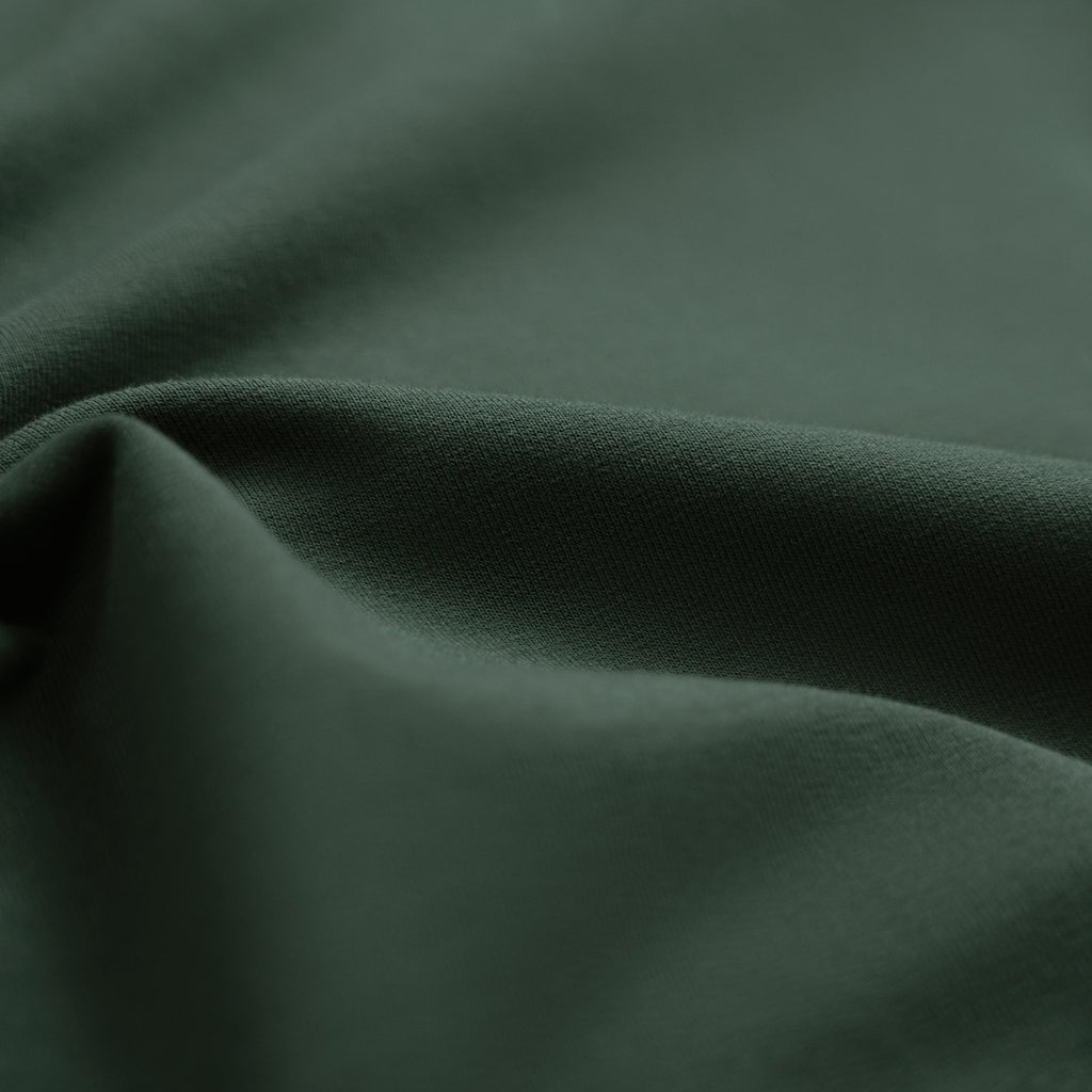 Man wearing a Pine Grove long-sleeve shirt against a beige background model Kive in Pine Grove