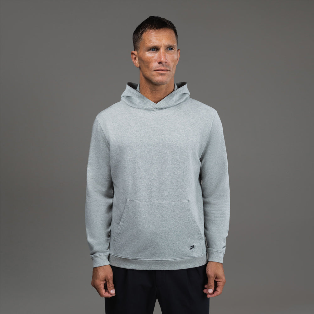 Man wearing a light gray hoodie against a plain background.