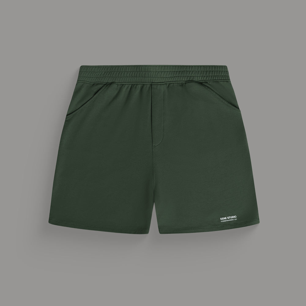 Dark green shorts with an elastic waistband and side pockets against a grey background.