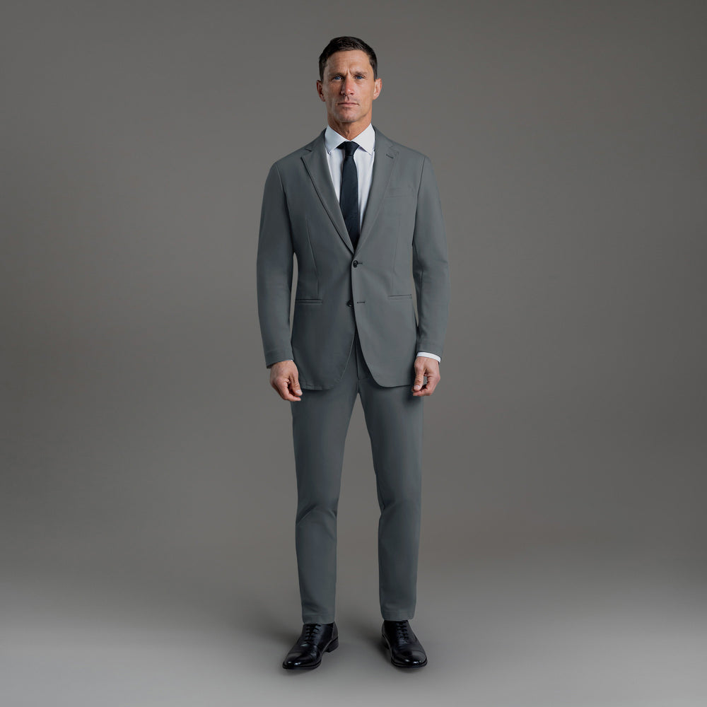 Man in a gray suit with neutral background.