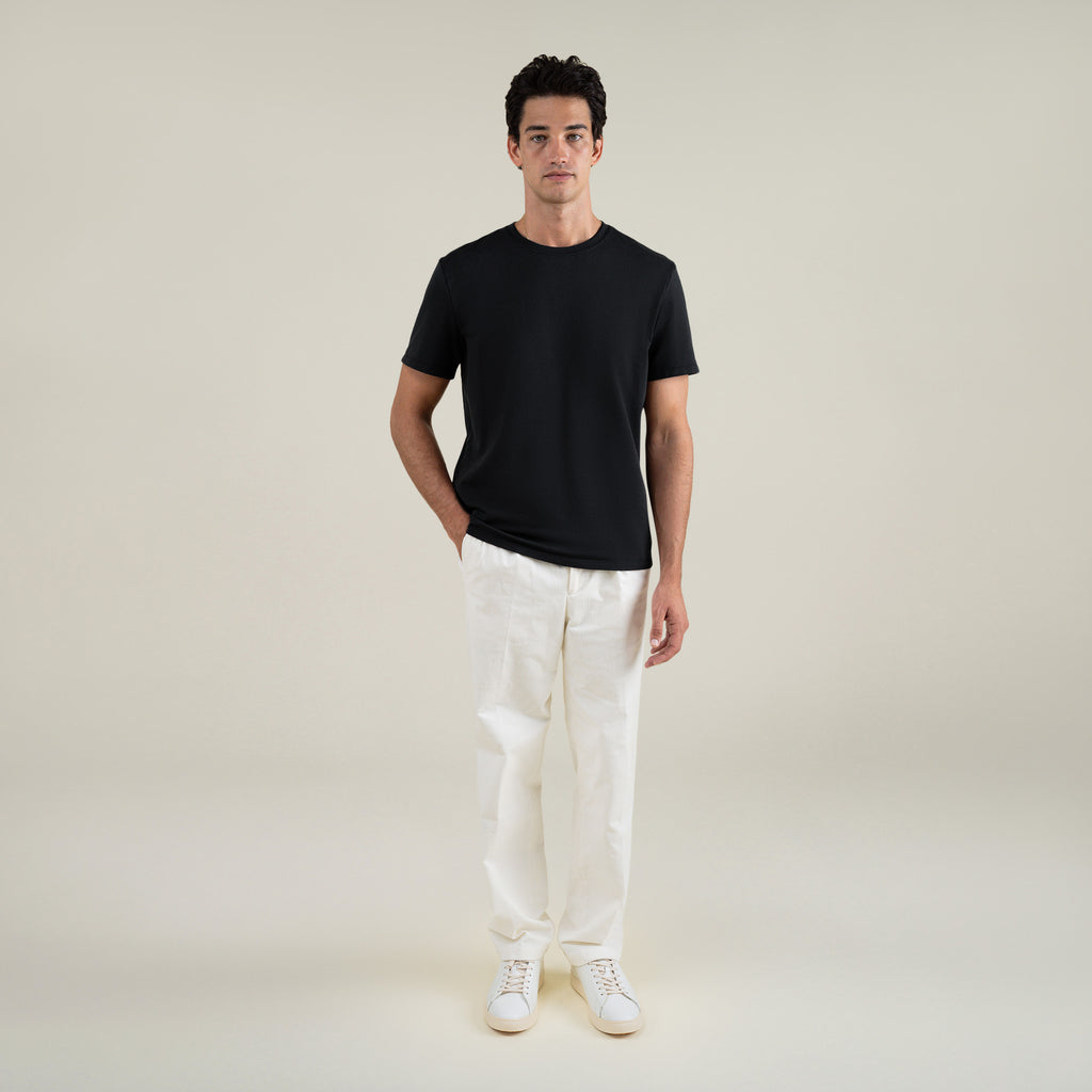 Three t-shirts in black, blue, and white on a beige background model Jessey in Shade