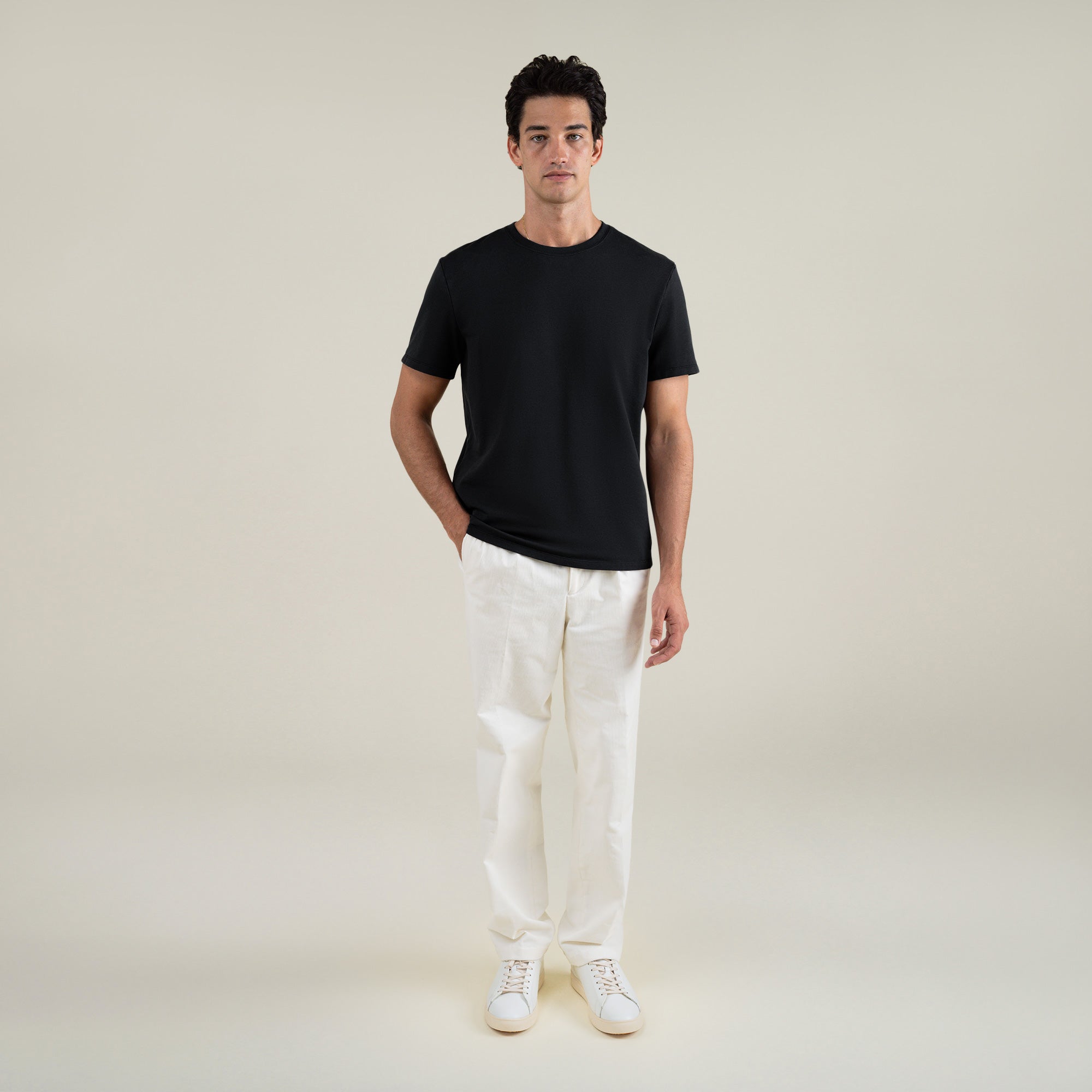 Three t-shirts in black, blue, and white on a beige background model Jessey in Shade