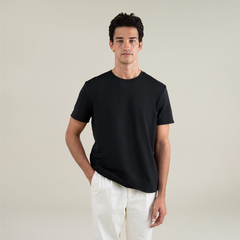 Three t-shirts in black, blue, and white on a beige background model Jessey in Shade