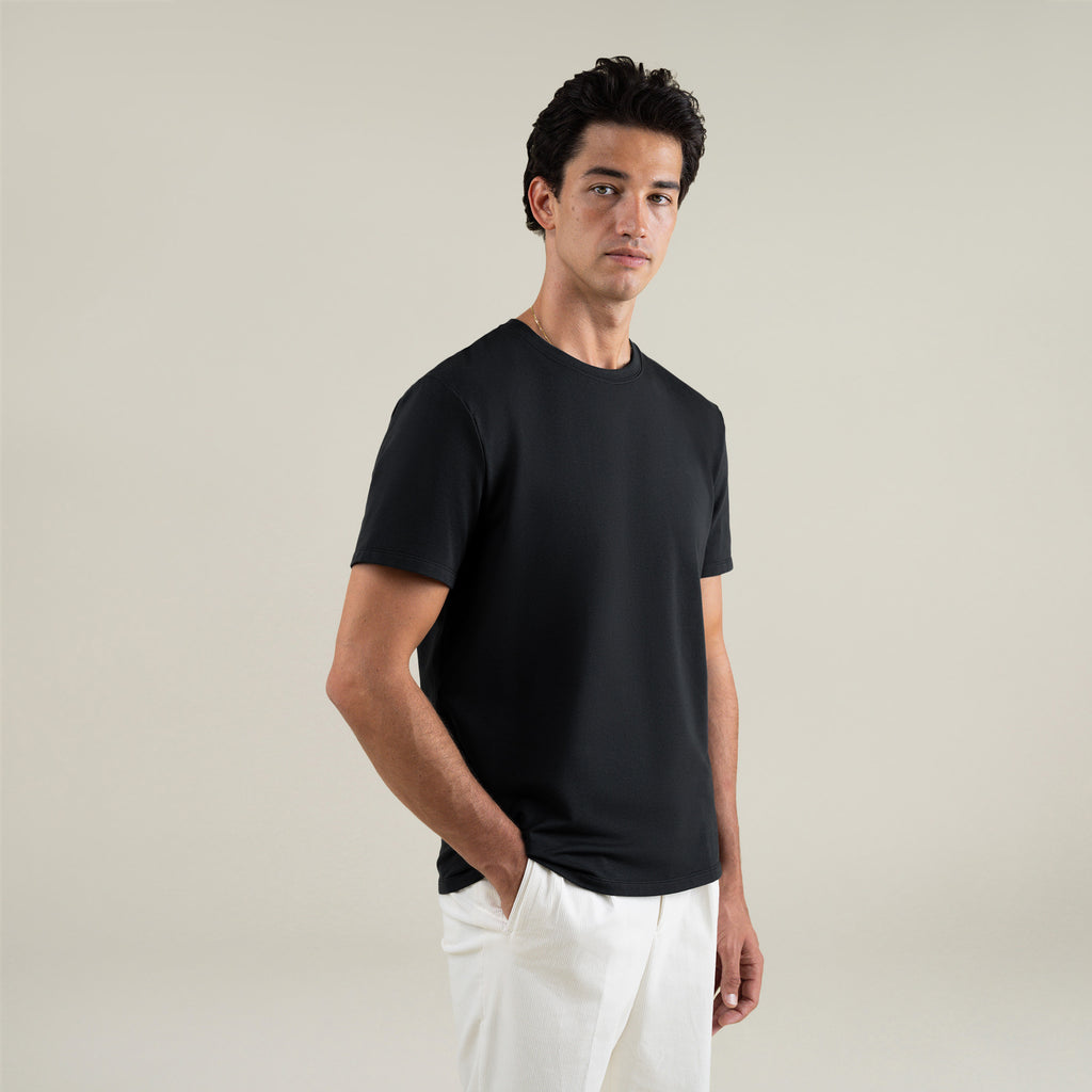 Three t-shirts in black, blue, and white on a beige background model Jessey in Shade