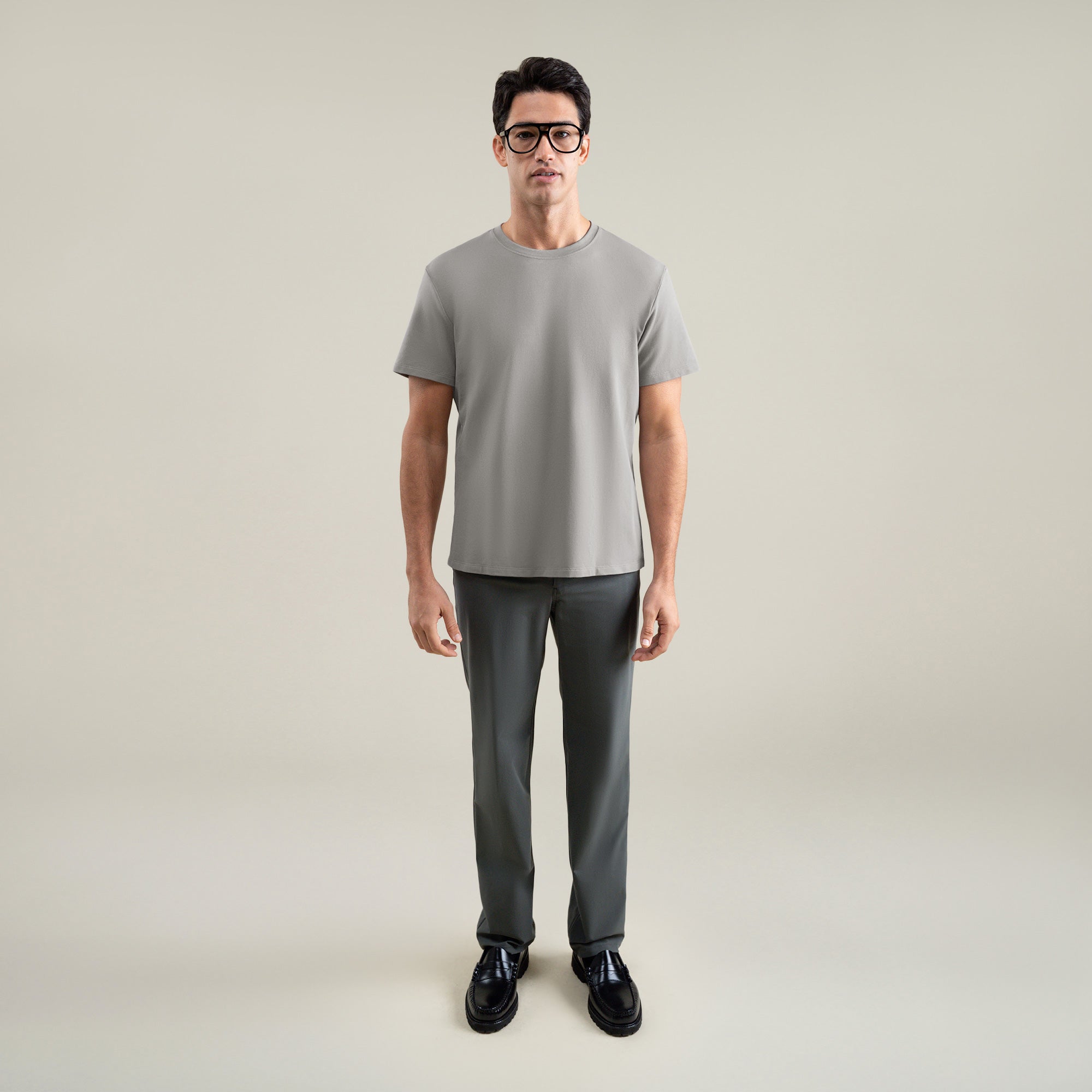 Six t-shirts in Black, Deep Sea, Moss, Umber, Frost Gray, and White on a beige background model Tyler in Best-Seller