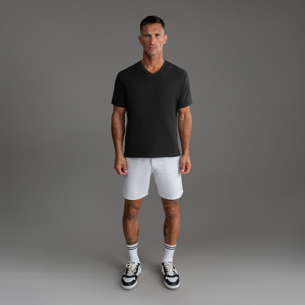 Cumulus v-neck t-shirt on a beige background model Tyler in Minimalist