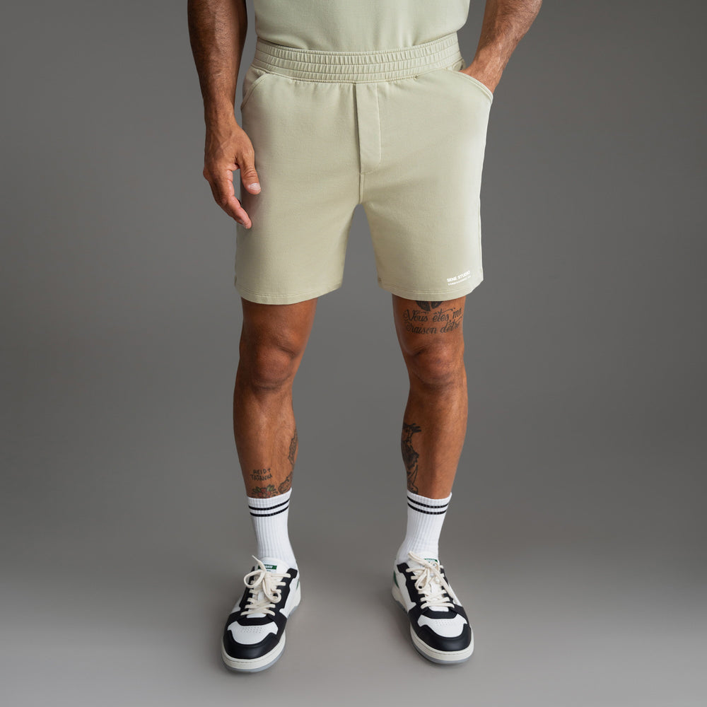 Man wearing beige shorts, white socks, and black sneakers.