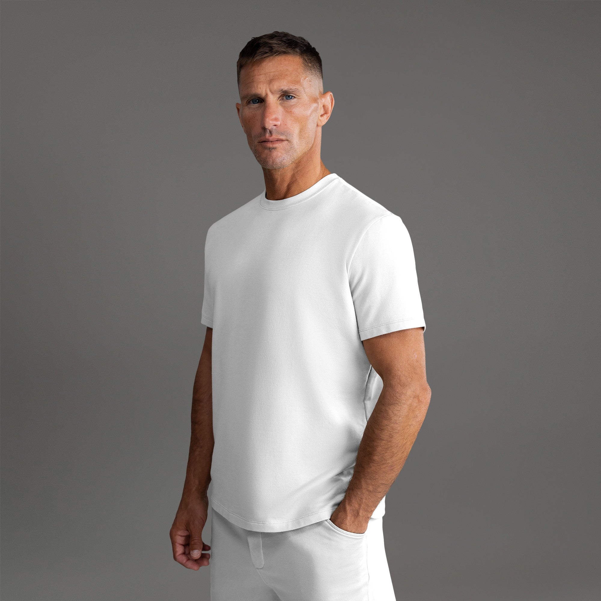 Three t-shirts in black, blue, and white on a beige background model Tyler in Shade