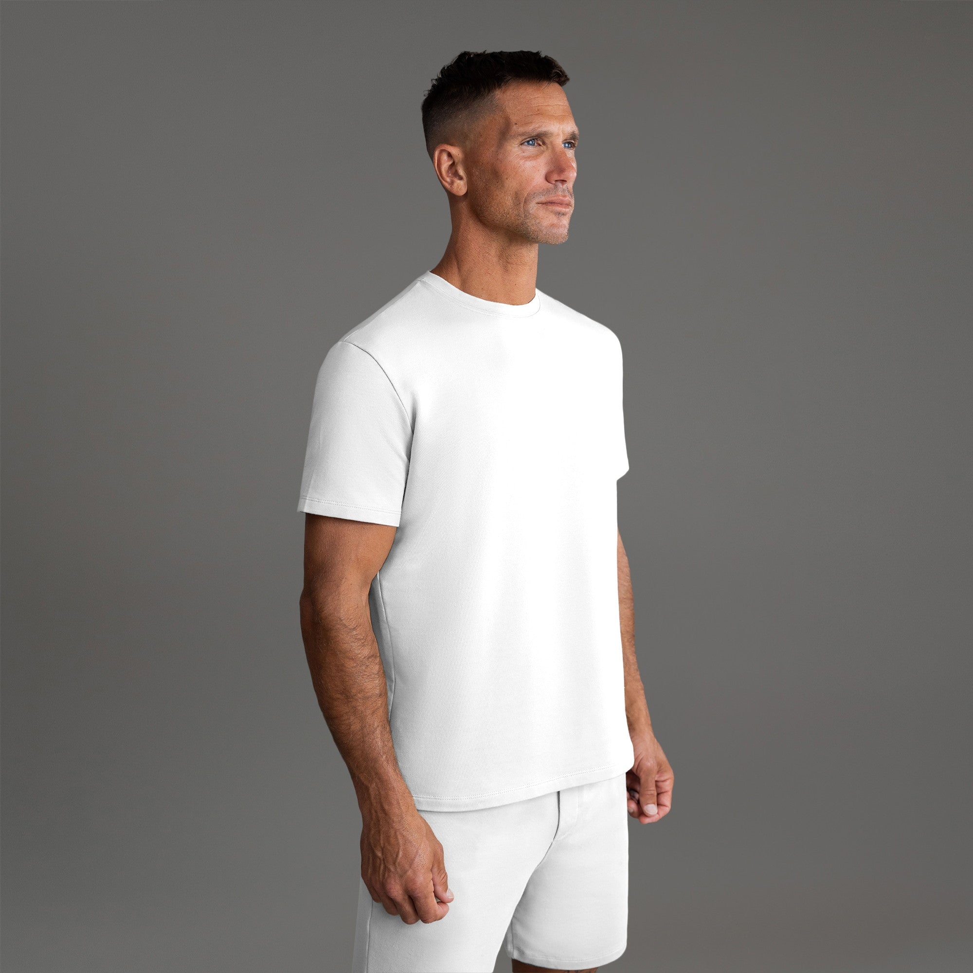Three t-shirts in black, blue, and white on a beige background model Tyler in Shade