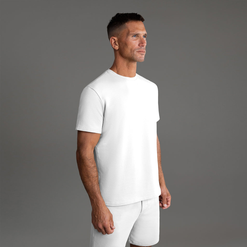Six t-shirts in Black, Deep Sea, Moss, Umber, Frost Gray, and White on a beige background model Tyler in Best-Seller