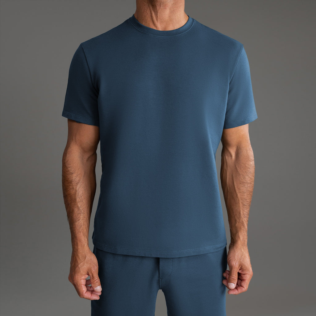 Three t-shirts in black, blue, and white on a beige background model Tyler in Shade