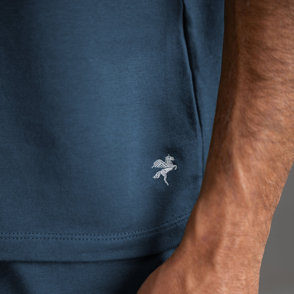 Three t-shirts in black, blue, and white on a beige background model Tyler in Shade