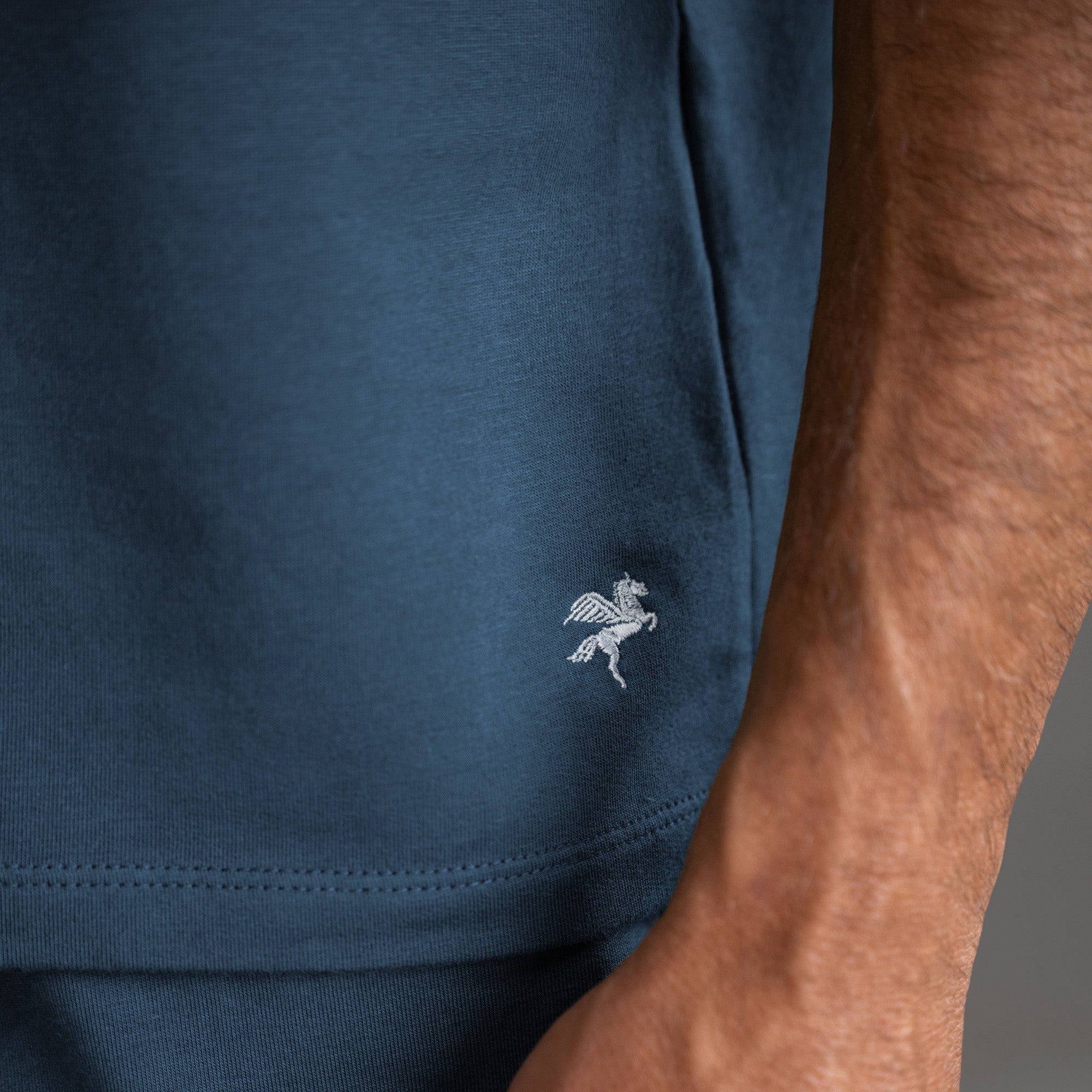 Three t-shirts in black, blue, and white on a beige background model Tyler in Shade