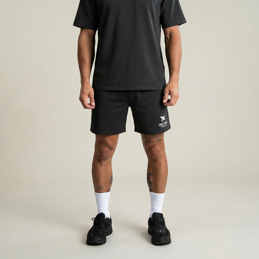 Person wearing black shorts with a logo on a plain background model Kive in Smoke