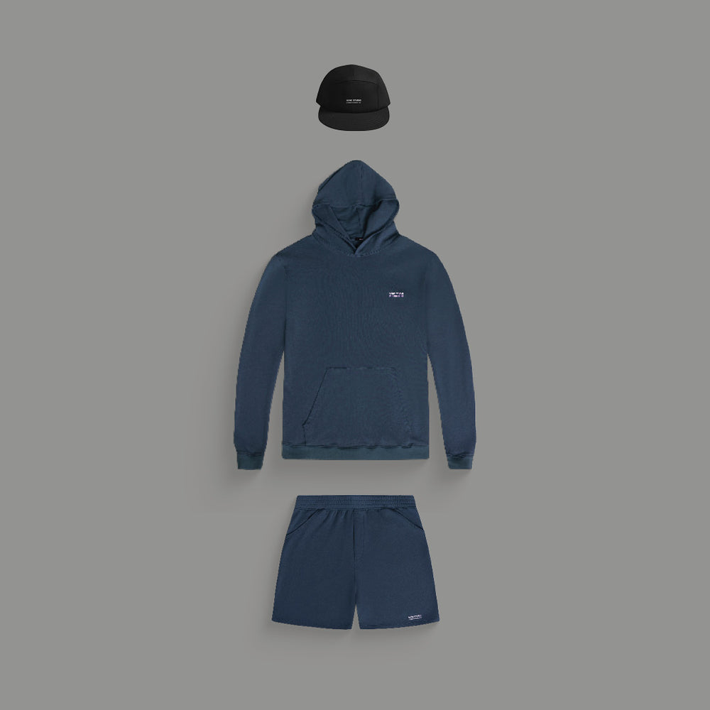 A dark blue hoodie, shorts, and a black cap on a gray background.