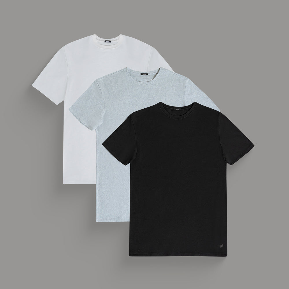 Three plain t-shirts in white, light gray, and black, arranged overlapping each other.