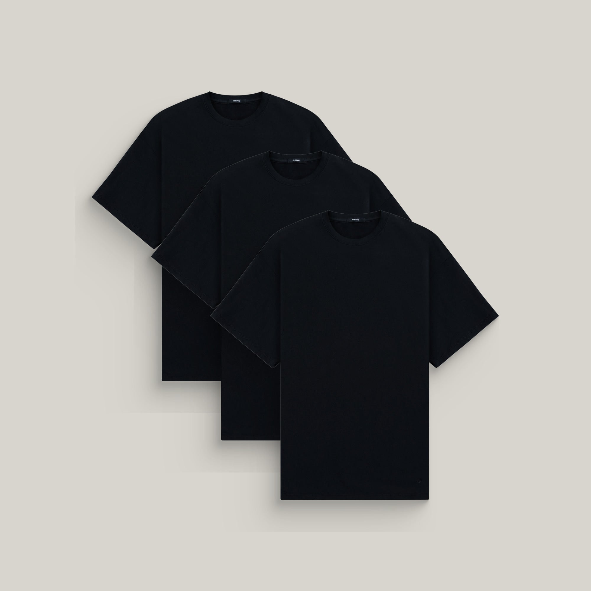 Three oversized t-shirts in black on a beige background model Kive in All-Black