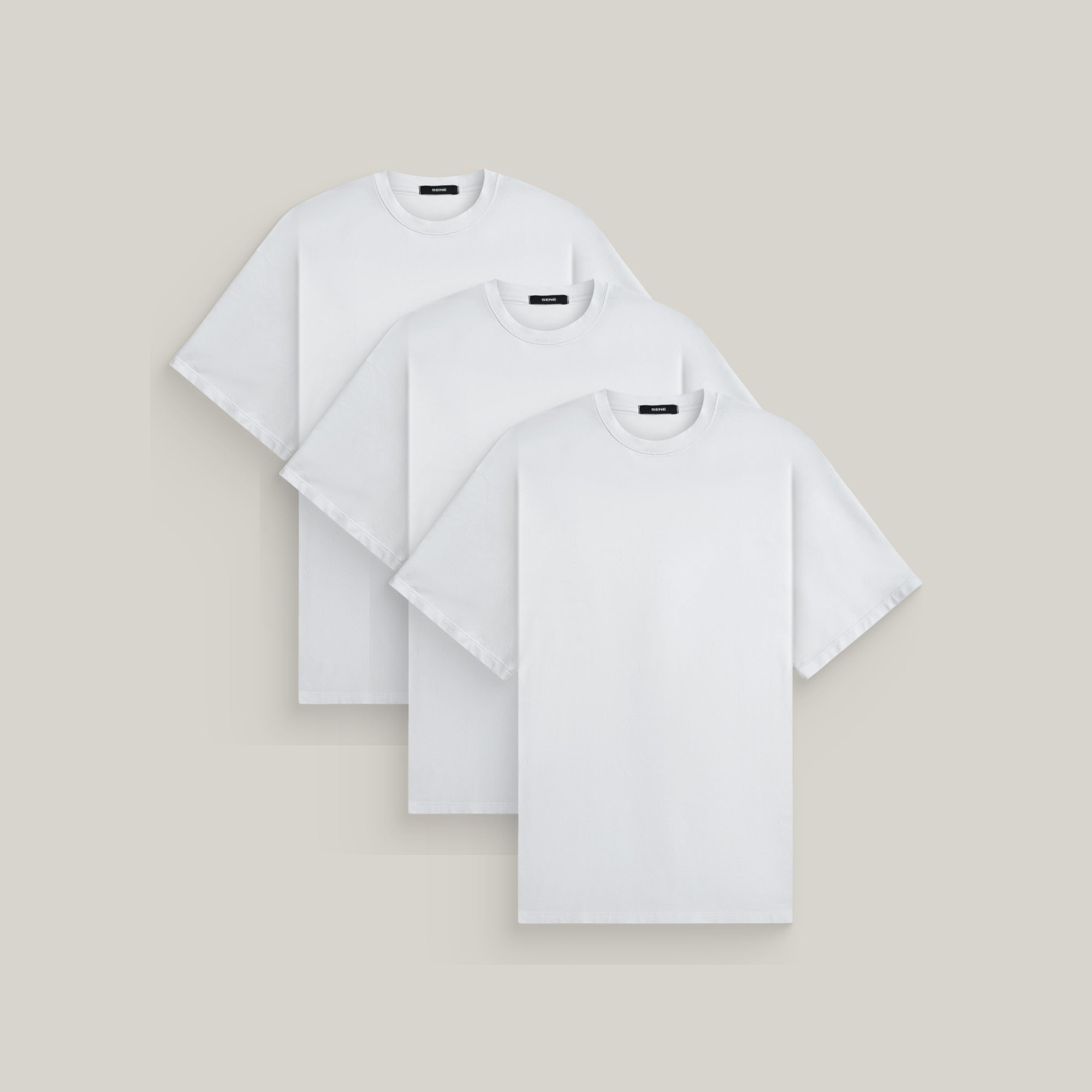 Three oversized t-shirts in white on a beige background model Kive in All-White