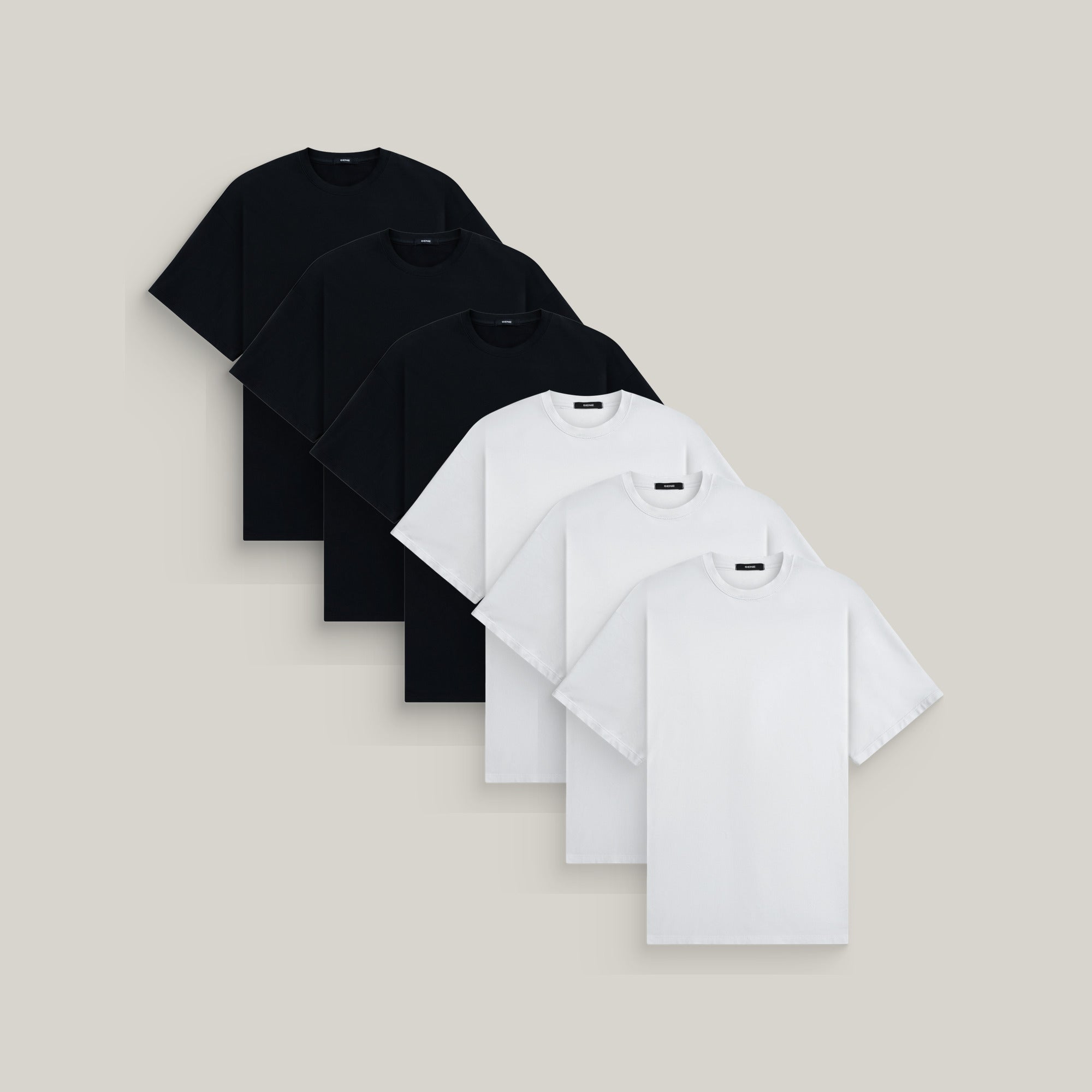 Six oversized t-shirts in black and white on a beige background model Kive in Essential