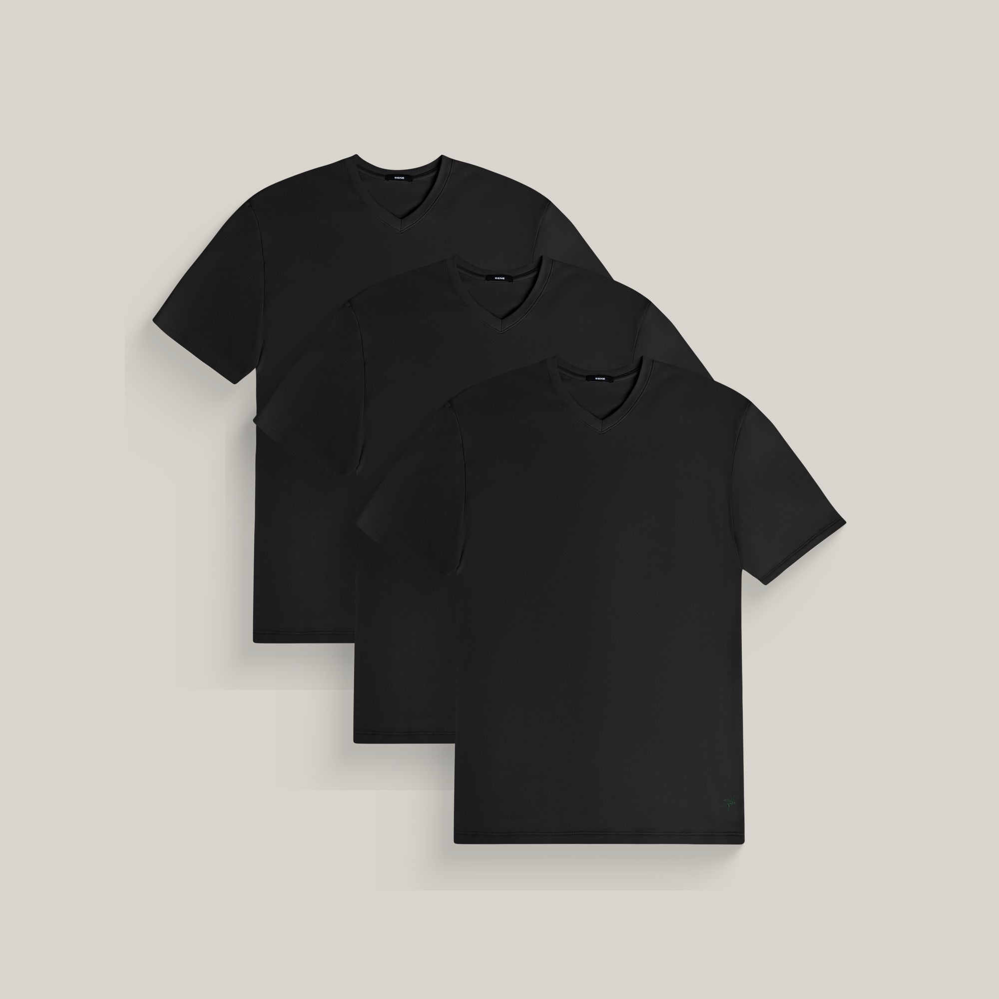Three v-neck t-shirts in black on a beige background model Tyler in All-Black