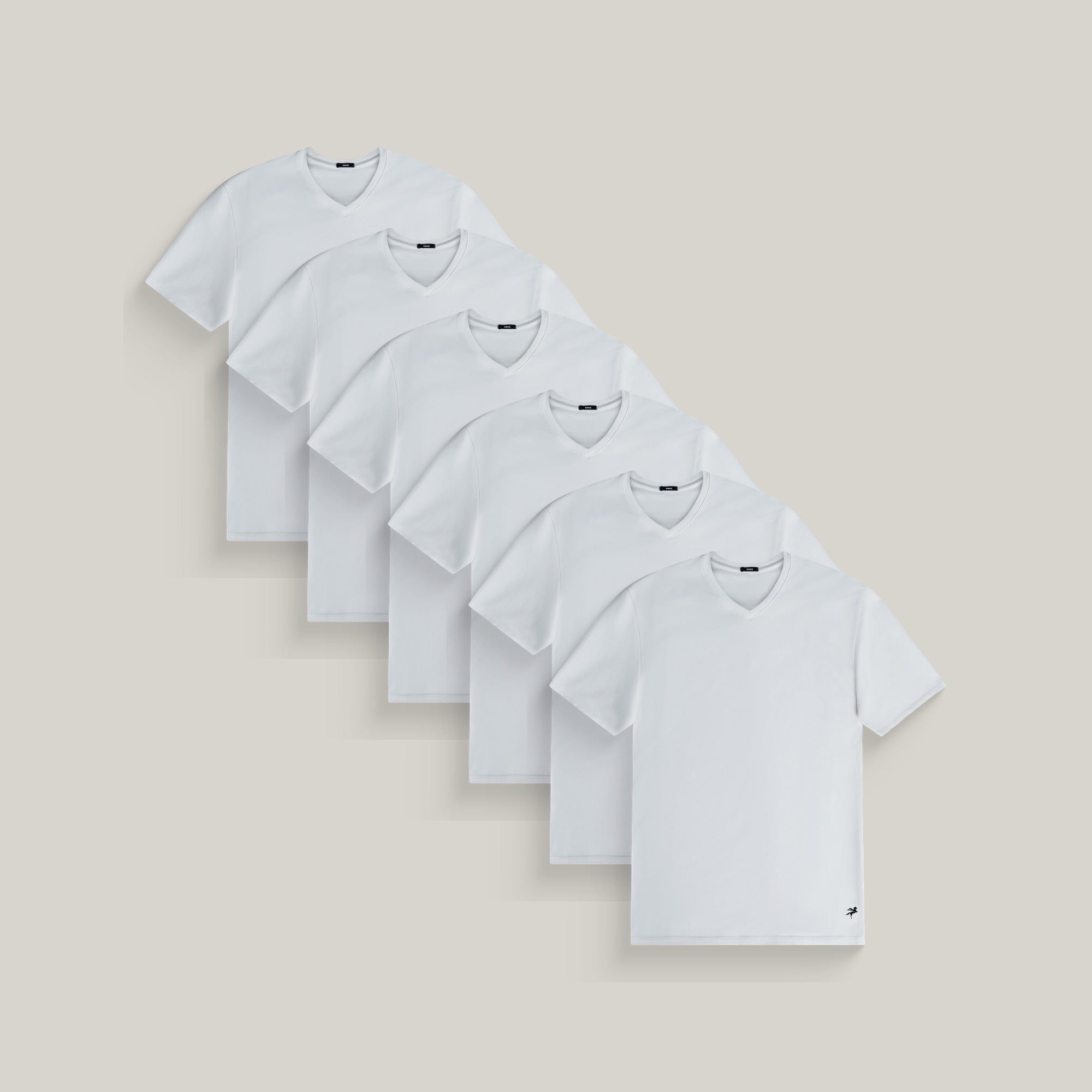 Six v-neck t-shirts in white on a beige background model Tyler in All-White