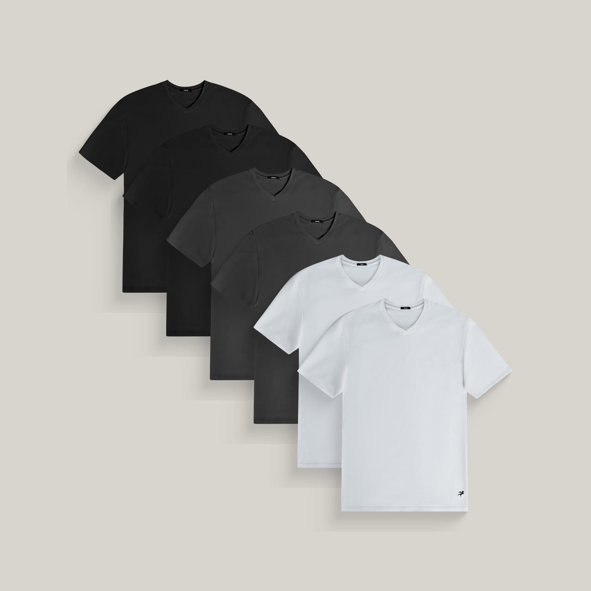 Six v-neck t-shirts in black, smoke and white on a beige background model Tyler in Core