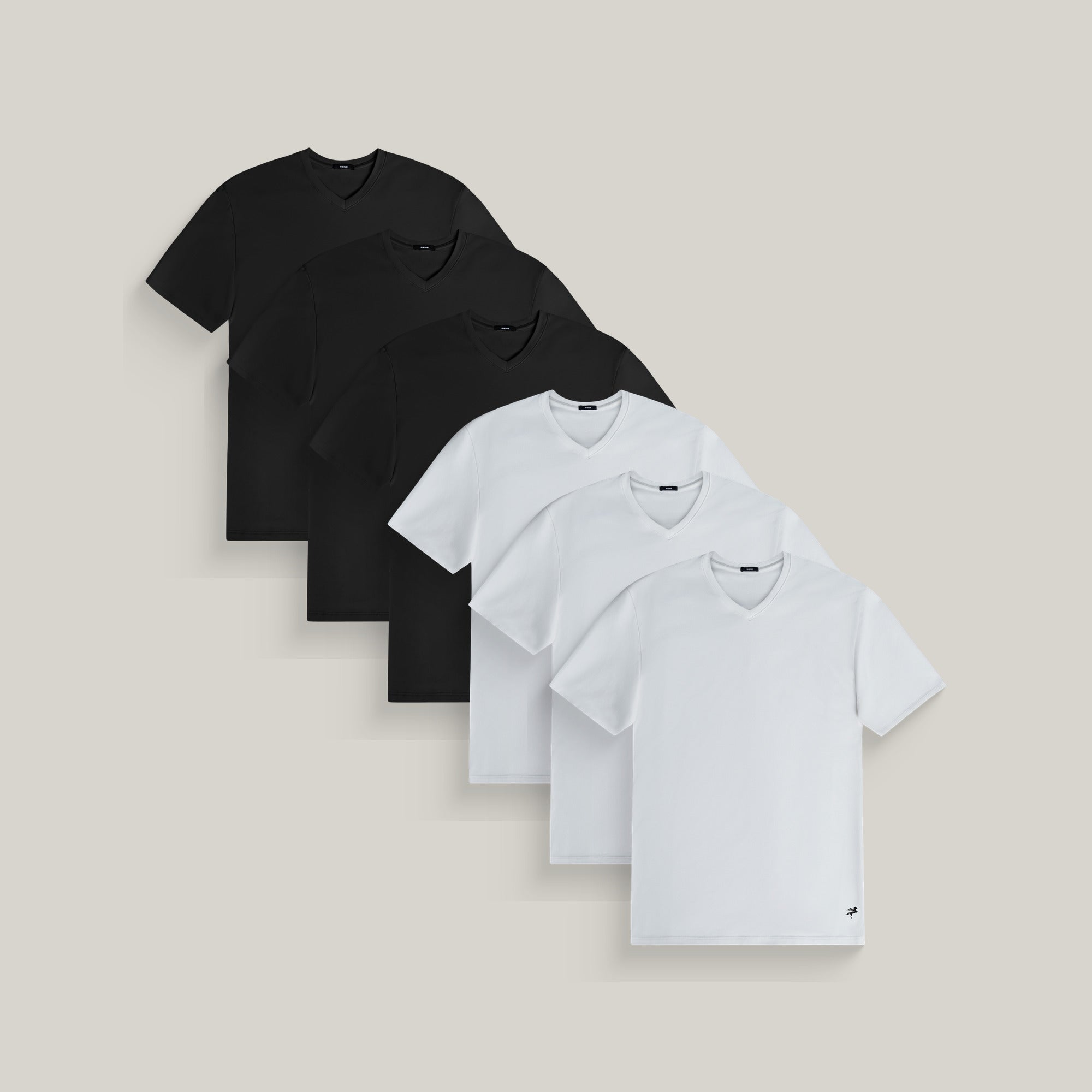 Six v-neck t-shirts in black and white on a beige background model Tyler in Essential