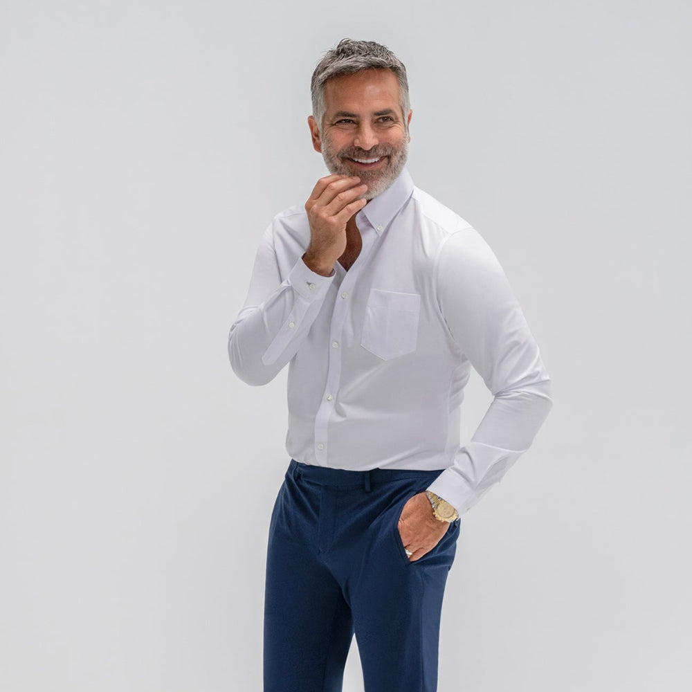 Close-up of a person wearing a white dress shirt and blue trousers.